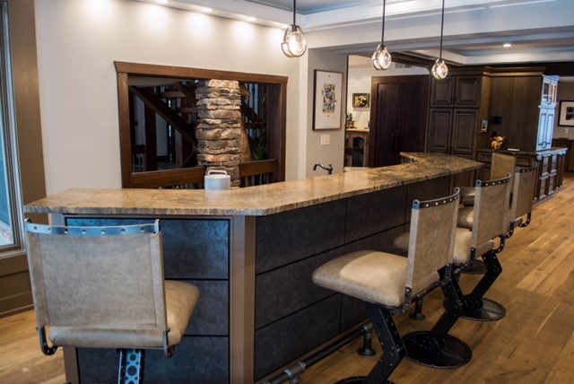 Inspiration for a mid-sized traditional u-shaped seated home bar in Cleveland with an undermount sink, flat-panel cabinets, brown cabinets, granite benchtops, medium hardwood floors, brown floor and brown benchtop.