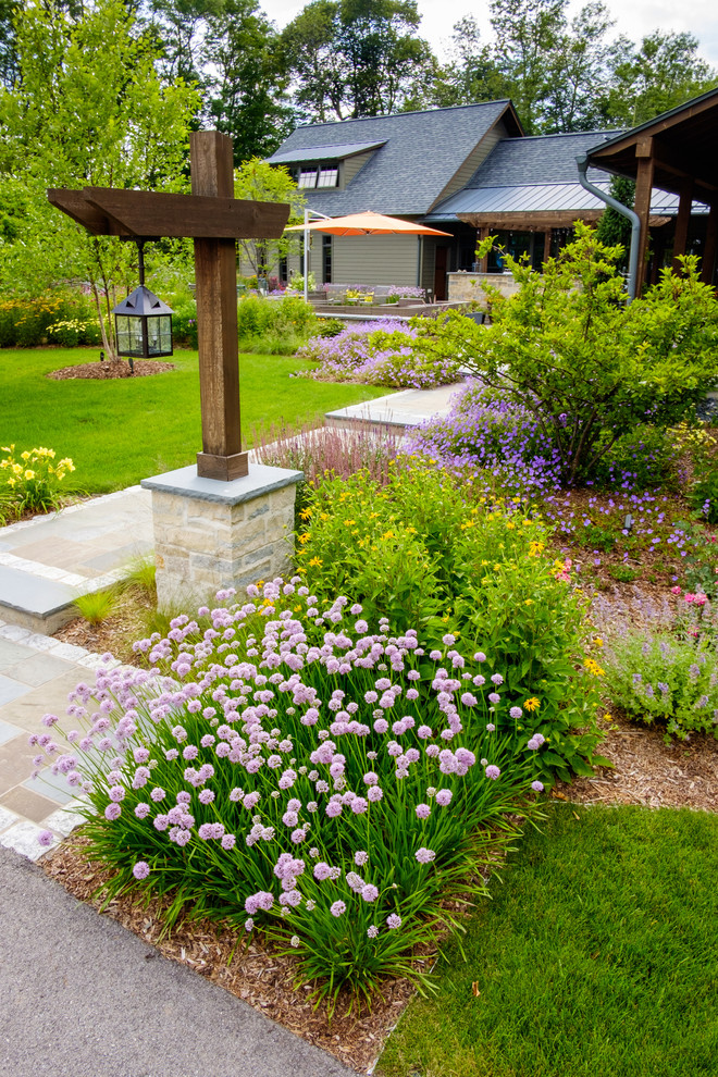 Photo of a large arts and crafts front yard garden in Milwaukee with natural stone pavers and a garden path.