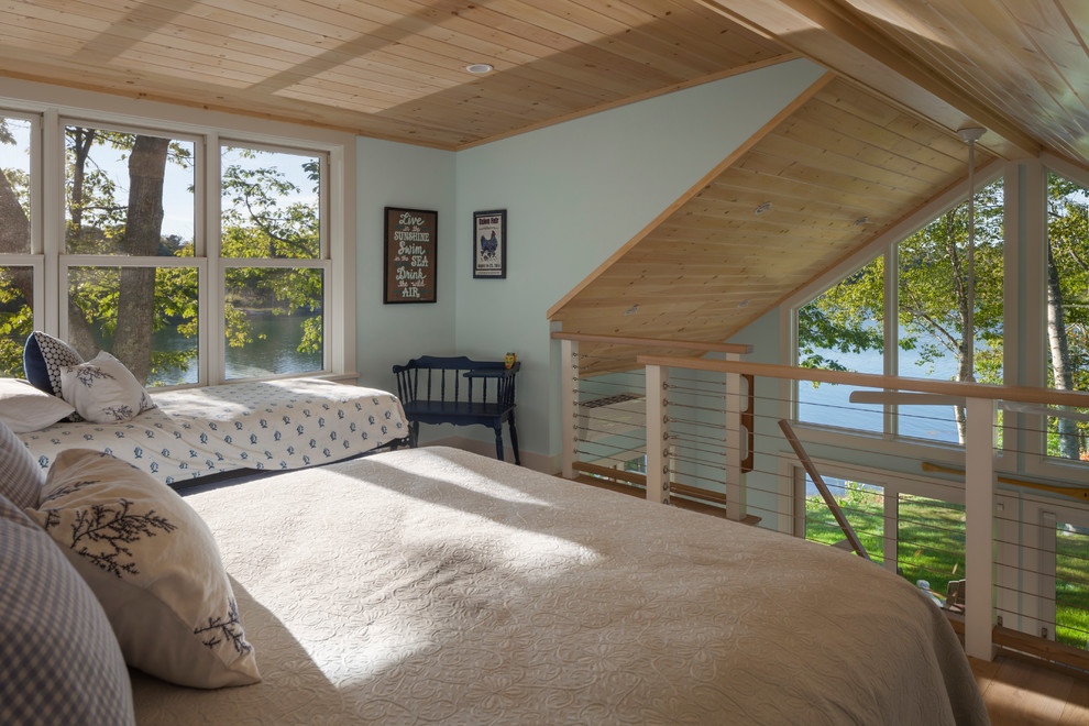 Inspiration for a small beach style bedroom in Portland Maine with blue walls, medium hardwood floors and brown floor.