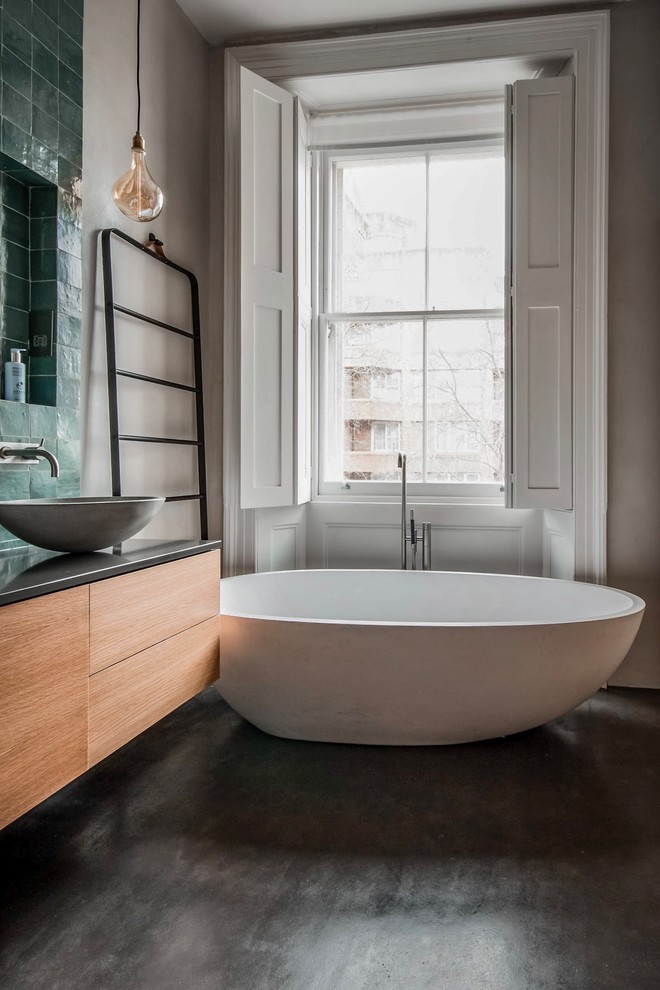 Inspiration for a large traditional 3/4 bathroom in London with furniture-like cabinets, brown cabinets, a freestanding tub, an open shower, a wall-mount toilet, brown tile, terra-cotta tile, beige walls, a wall-mount sink, wood benchtops, beige floor and an open shower.