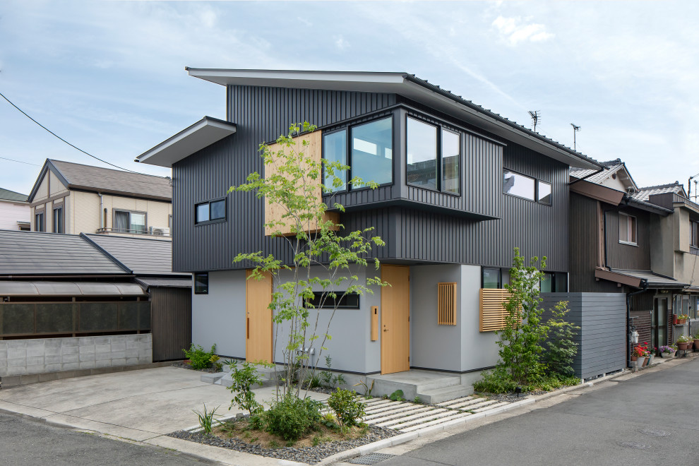 This is an example of a contemporary two-storey grey house exterior in Other with a shed roof.