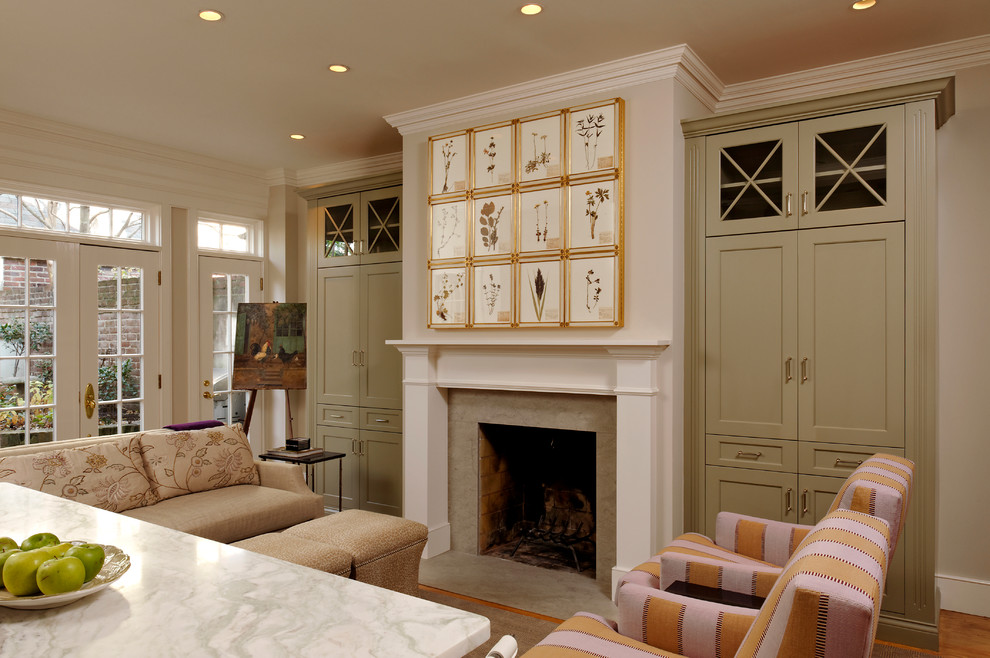 Photo of a traditional family room in DC Metro with light hardwood floors, a standard fireplace, a stone fireplace surround and a concealed tv.