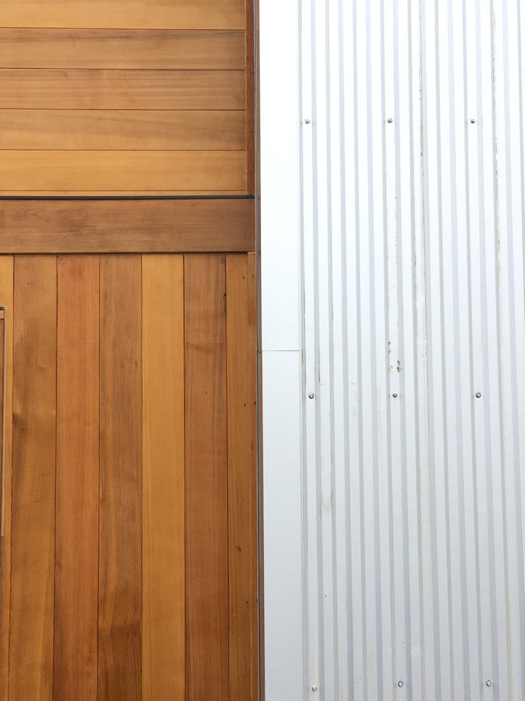 Minimalist three-story mixed siding home design photo in Minneapolis with a shed roof and a metal roof
