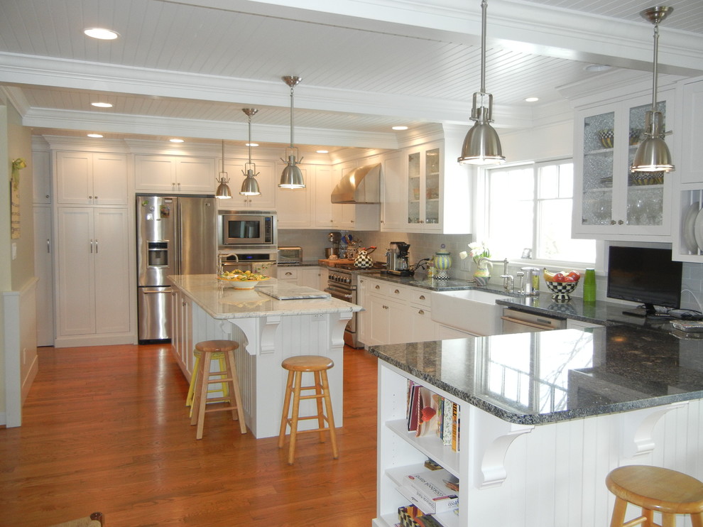 Example of a large transitional u-shaped medium tone wood floor, brown floor and shiplap ceiling open concept kitchen design with a farmhouse sink, shaker cabinets, white cabinets, granite countertops, subway tile backsplash, stainless steel appliances, an island and white backsplash