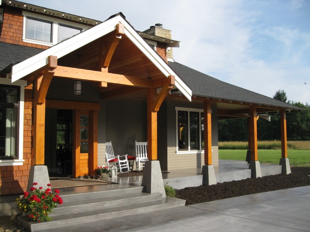 This is an example of a large traditional entryway in Seattle with grey walls, concrete floors, a single front door and a medium wood front door.