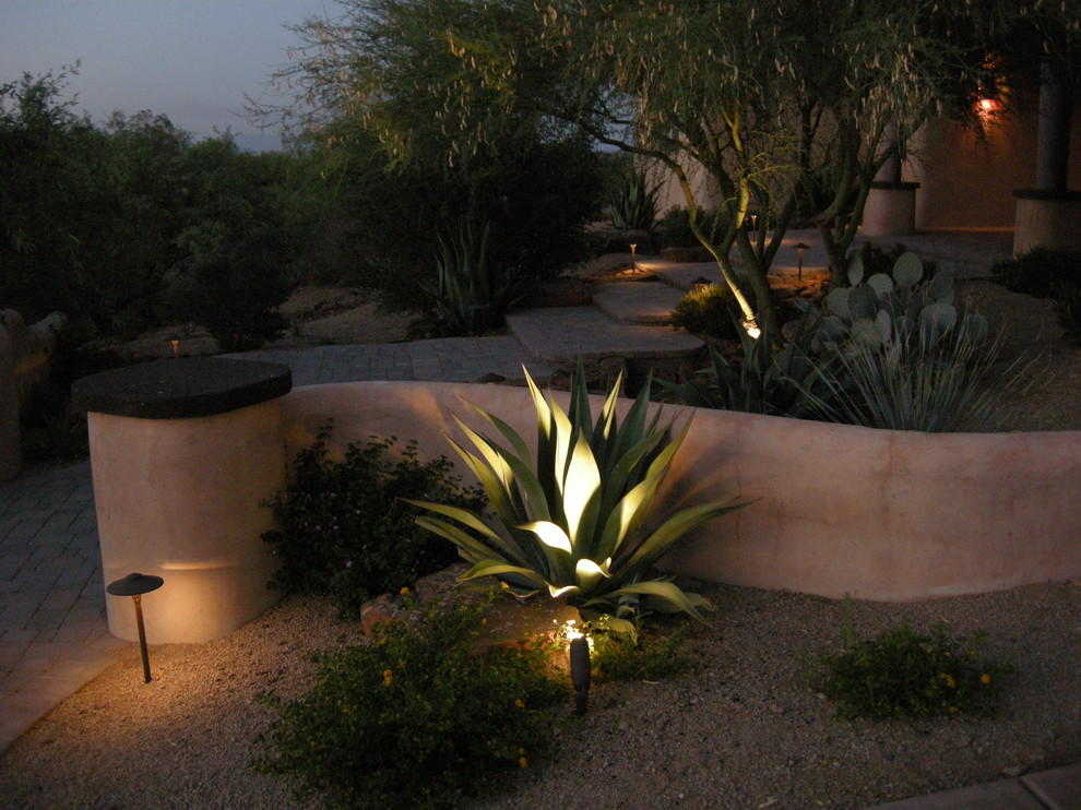Inspiration for a mid-sized front yard partial sun xeriscape for summer in Phoenix with a retaining wall and brick pavers.