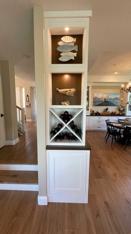 Inspiration for a large transitional l-shaped kitchen pantry in Orange County with a farmhouse sink, shaker cabinets, white cabinets, wood benchtops, multi-coloured splashback, ceramic splashback, stainless steel appliances, light hardwood floors, with island, brown floor, white benchtop and vaulted.