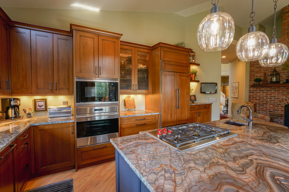 Inspiration for a mid-sized transitional medium tone wood floor and brown floor kitchen remodel in Denver with a farmhouse sink, recessed-panel cabinets, medium tone wood cabinets, granite countertops, paneled appliances and an island