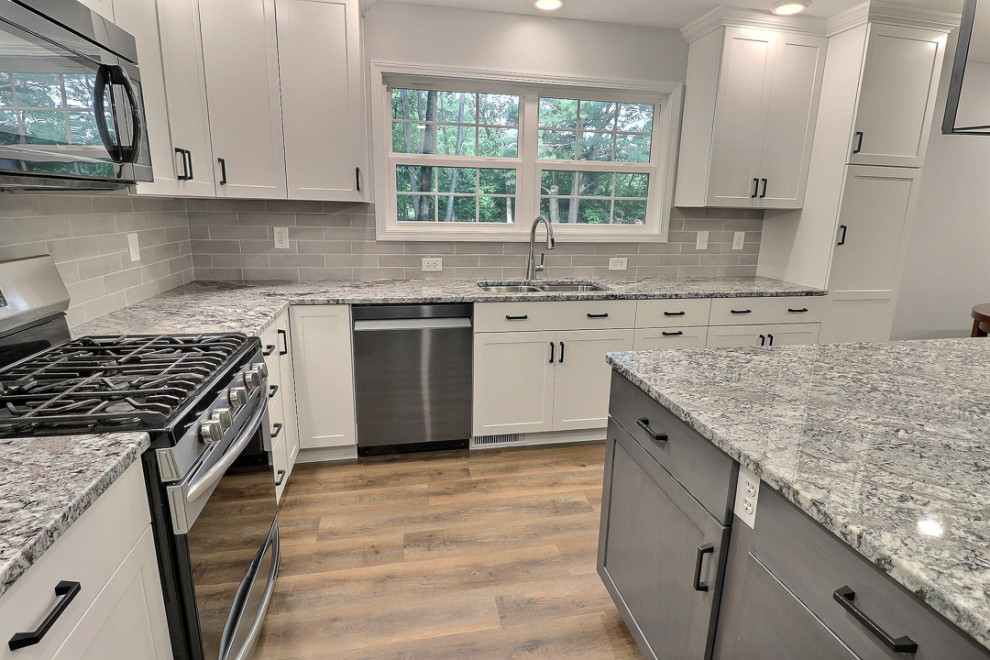Idéer för att renovera ett stort vintage flerfärgad flerfärgat kök, med en undermonterad diskho, skåp i shakerstil, vita skåp, granitbänkskiva, grått stänkskydd, stänkskydd i porslinskakel, svarta vitvaror, vinylgolv, en köksö och brunt golv