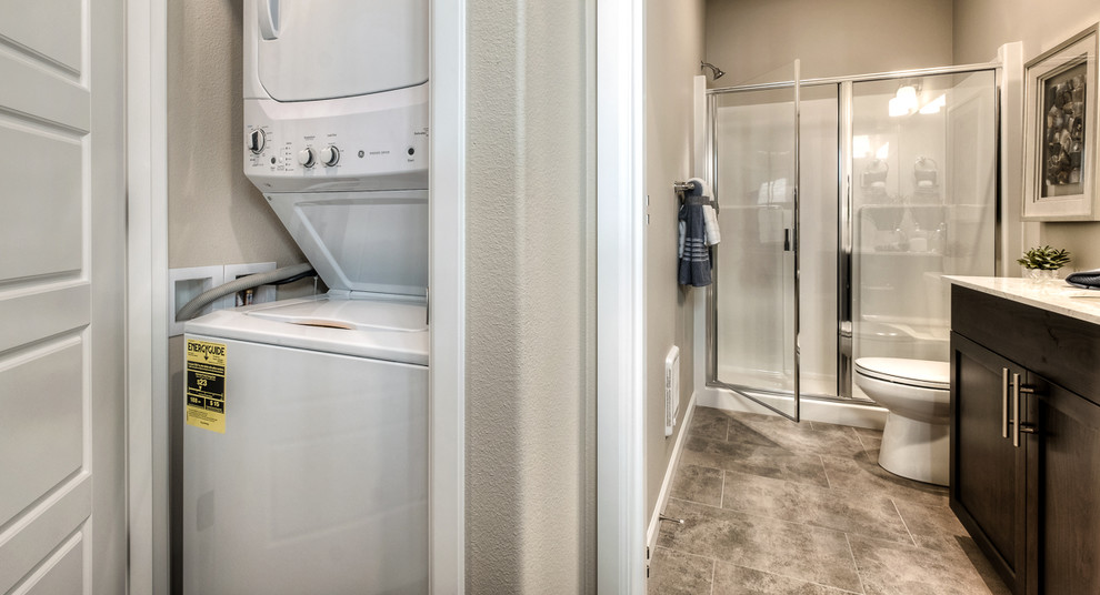 This is an example of a mid-sized traditional 3/4 bathroom in Seattle with beaded inset cabinets, brown cabinets, an alcove shower, a one-piece toilet, beige walls, laminate floors, a drop-in sink, quartzite benchtops, brown floor, a hinged shower door and white benchtops.
