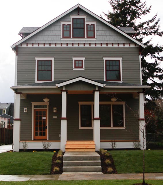 Inspiration for a large arts and crafts three-storey green exterior in Portland with wood siding.