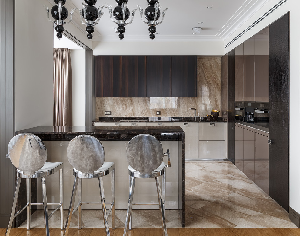 Inspiration for a contemporary l-shaped eat-in kitchen in Moscow with dark wood cabinets, marble benchtops, beige splashback, marble splashback, ceramic floors, beige floor, flat-panel cabinets, a peninsula, black benchtop and black appliances.