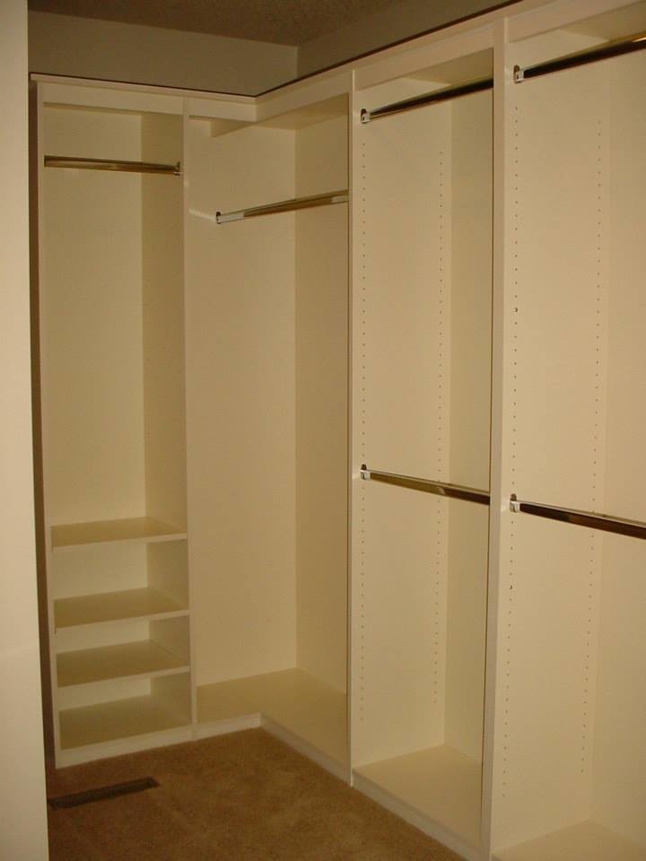 Gender-neutral carpeted closet photo with white cabinets