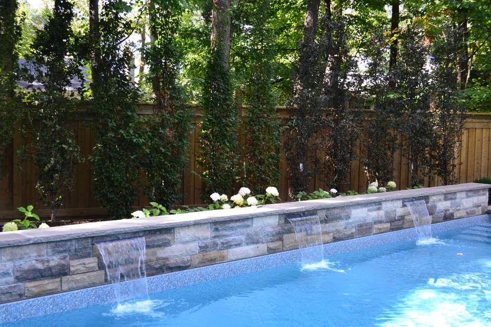 Example of a large transitional backyard tile and rectangular lap hot tub design in Toronto