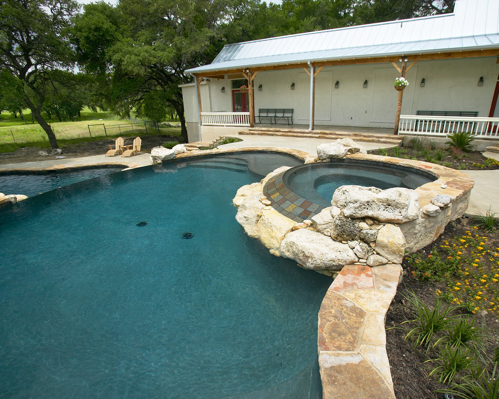 Example of a large mountain style courtyard concrete and custom-shaped natural home design design in Austin