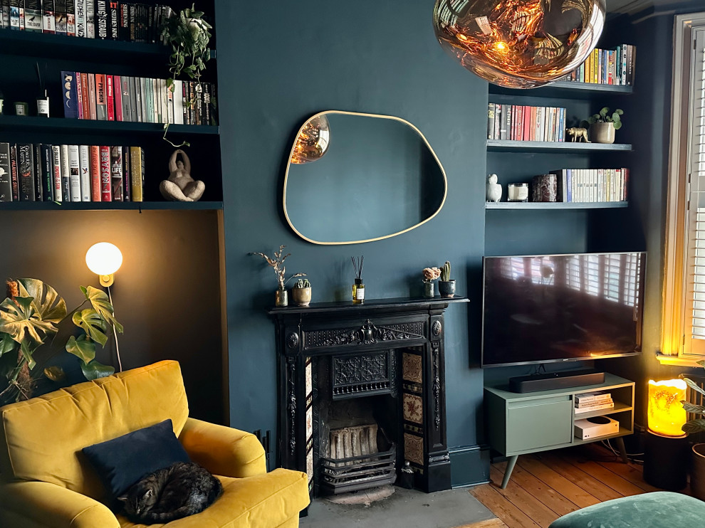 Inspiration for a medium sized contemporary enclosed living room in London with blue walls, medium hardwood flooring, a standard fireplace, a metal fireplace surround, a wall mounted tv, brown floors and a chimney breast.