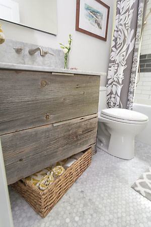 This is an example of a mid-sized eclectic bathroom in Other with shaker cabinets, blue cabinets, a shower/bathtub combo, a one-piece toilet, multi-coloured tile, cement tile, grey walls, medium hardwood floors, a drop-in sink and marble benchtops.