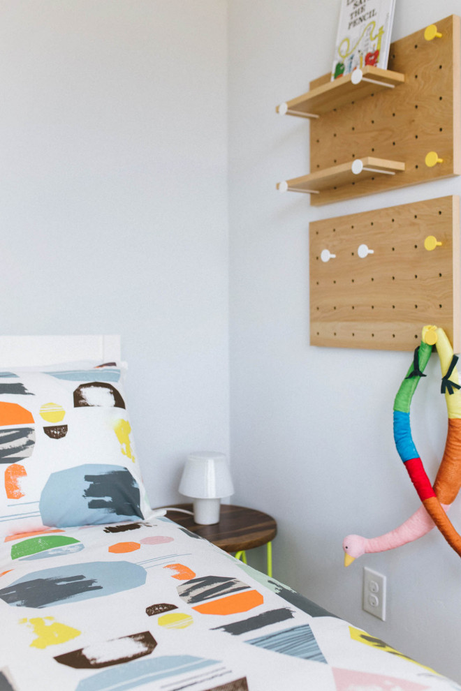 Modern inredning av ett stort könsneutralt småbarnsrum kombinerat med sovrum, med grå väggar, heltäckningsmatta och beiget golv