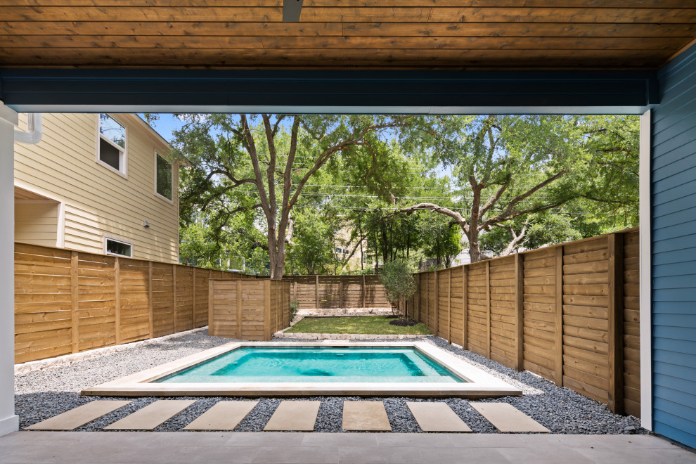 Photo of a mid-sized contemporary backyard rectangular pool in Austin with with privacy feature and gravel.