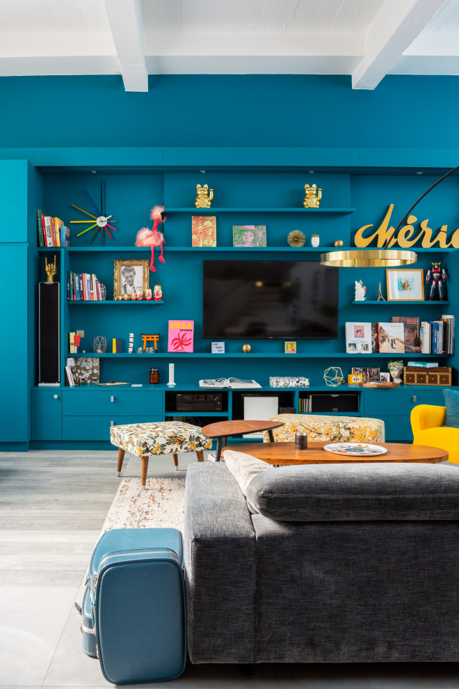Immagine di un grande soggiorno minimal aperto con libreria, pareti blu, TV a parete e pavimento beige