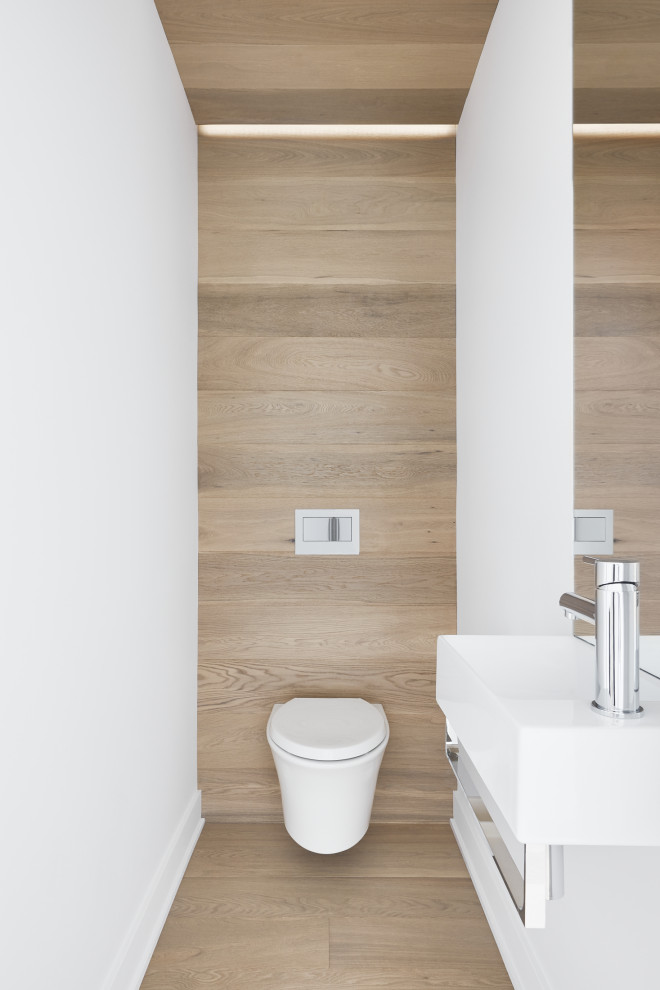 Small modern powder room in Montreal with a wall-mount toilet, white walls, light hardwood floors, a wall-mount sink, a floating vanity and wood.