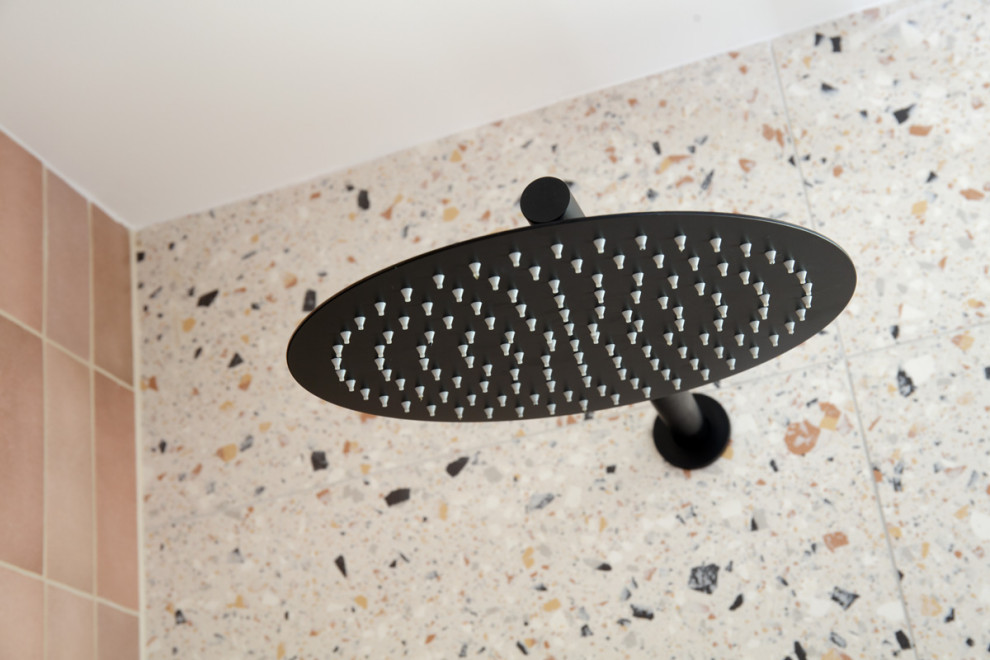 This is an example of a small mediterranean bathroom in Brisbane with furniture-like cabinets, white cabinets, a two-piece toilet, multi-coloured tile, porcelain tile, multi-coloured walls, porcelain floors, a vessel sink, engineered quartz benchtops, multi-coloured floor, white benchtops, a single vanity and a freestanding vanity.