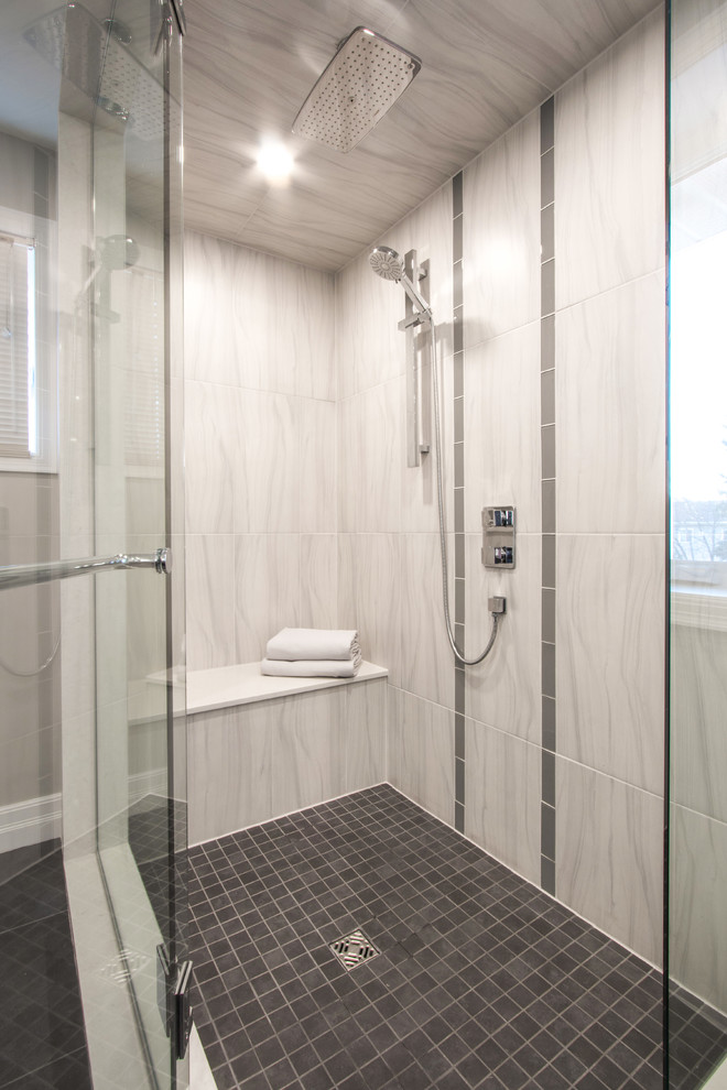 This is an example of a large modern master bathroom in Toronto with flat-panel cabinets, medium wood cabinets, a corner shower, a one-piece toilet, gray tile, porcelain tile, grey walls, porcelain floors, an undermount sink and engineered quartz benchtops.