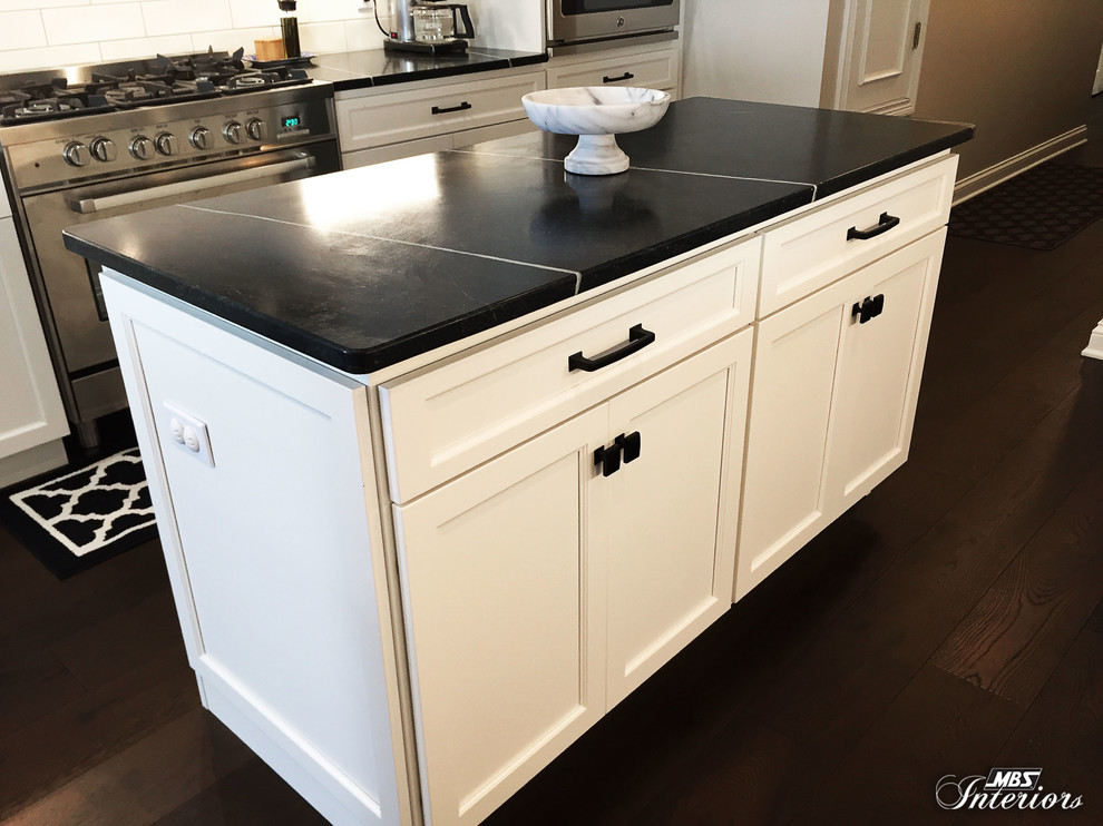 Eat-in kitchen - mid-sized transitional u-shaped dark wood floor and brown floor eat-in kitchen idea with an undermount sink, recessed-panel cabinets, white cabinets, soapstone countertops, white backsplash, subway tile backsplash, stainless steel appliances and an island