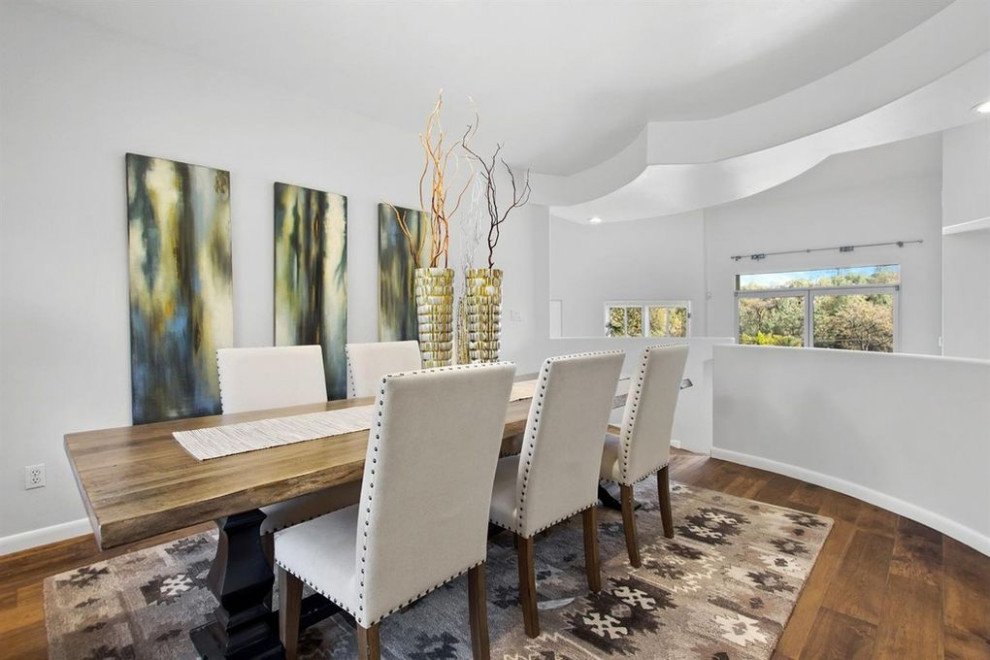 This is an example of a large contemporary separate dining room in Sacramento with white walls, medium hardwood floors and brown floor.