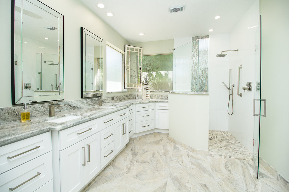 This is an example of a large contemporary master bathroom in Houston with shaker cabinets, white cabinets, a corner shower, white tile, porcelain tile, grey walls, porcelain floors, an undermount sink, beige floor, a hinged shower door, quartzite benchtops and white benchtops.