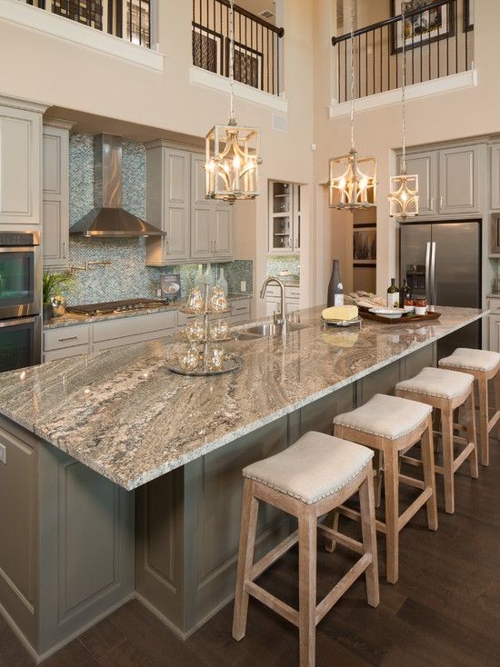 Inspiration for a large traditional l-shaped kitchen in Cleveland with a double-bowl sink, raised-panel cabinets, white cabinets, granite benchtops, blue splashback, glass tile splashback, stainless steel appliances, dark hardwood floors, with island and brown floor.