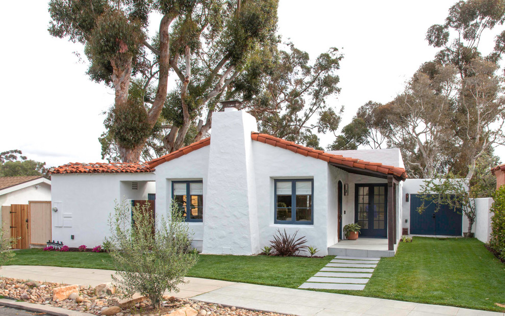 Photo of a mid-sized mediterranean one-storey stucco white house exterior in San Diego with a gable roof and a tile roof.