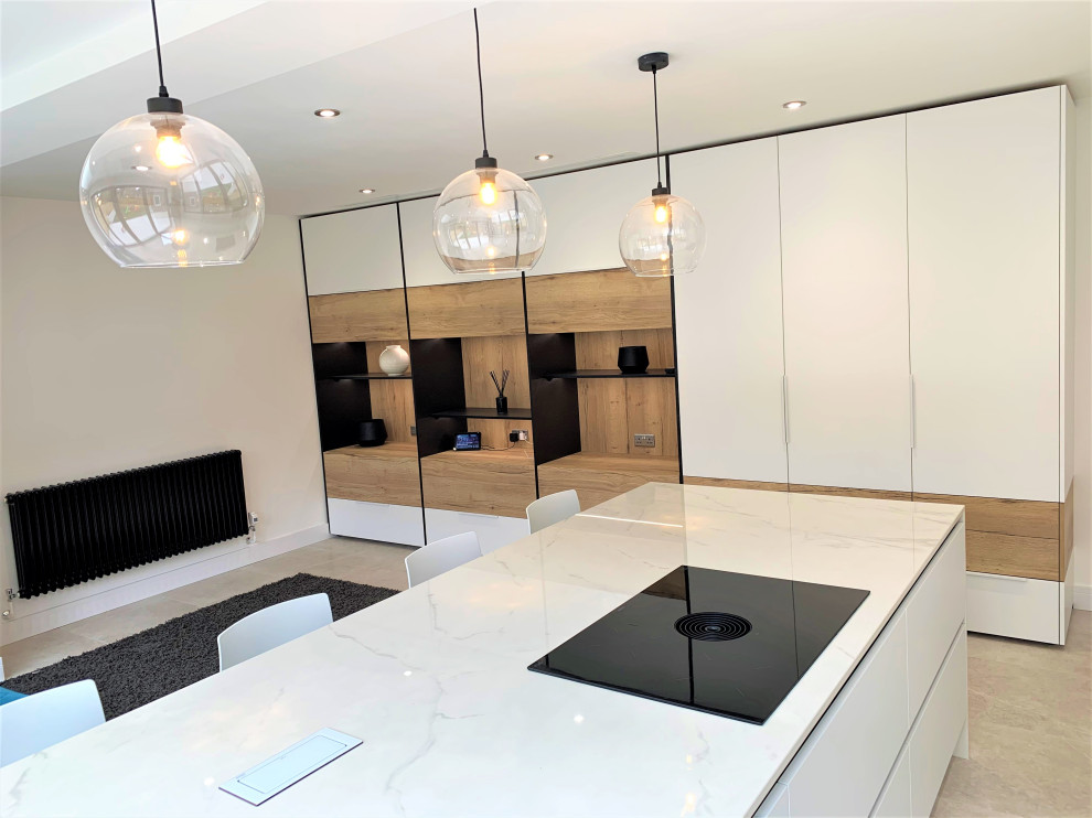 Immagine di una cucina minimal di medie dimensioni con lavello integrato, ante lisce, ante in legno scuro, top in superficie solida, elettrodomestici neri, pavimento in vinile e top bianco
