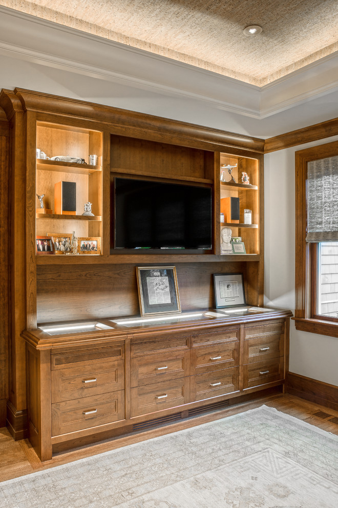 Large traditional home office in Boston with grey walls, medium hardwood floors, a freestanding desk, no fireplace, brown floor and a library.