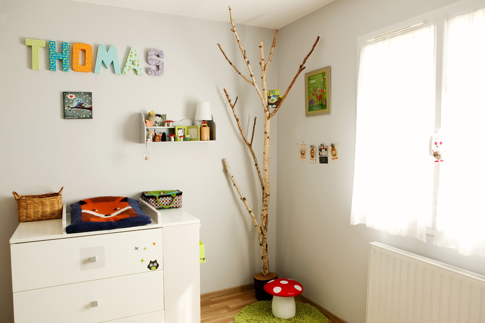 Mid-sized contemporary nursery in Clermont-Ferrand with white walls and medium hardwood floors for boys.
