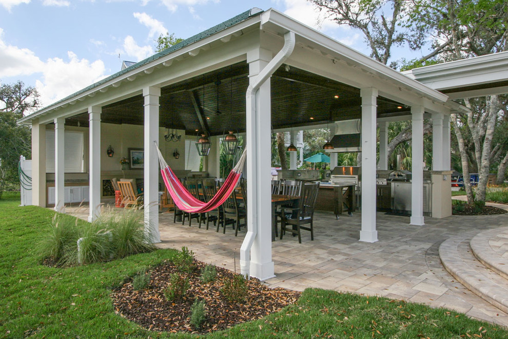 Expansive beach style backyard patio in Other with an outdoor kitchen, concrete pavers and a roof extension.