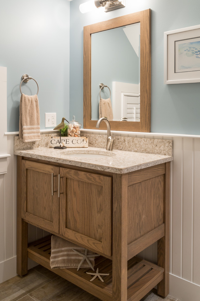 Inspiration for a mid-sized beach style 3/4 bathroom in Boston with shaker cabinets, medium wood cabinets, an alcove shower, blue walls, medium hardwood floors, an undermount sink, granite benchtops, brown floor and a hinged shower door.
