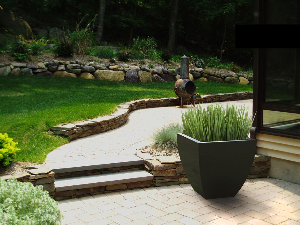 Large contemporary backyard full sun formal garden in Toronto with a container garden and natural stone pavers for summer.
