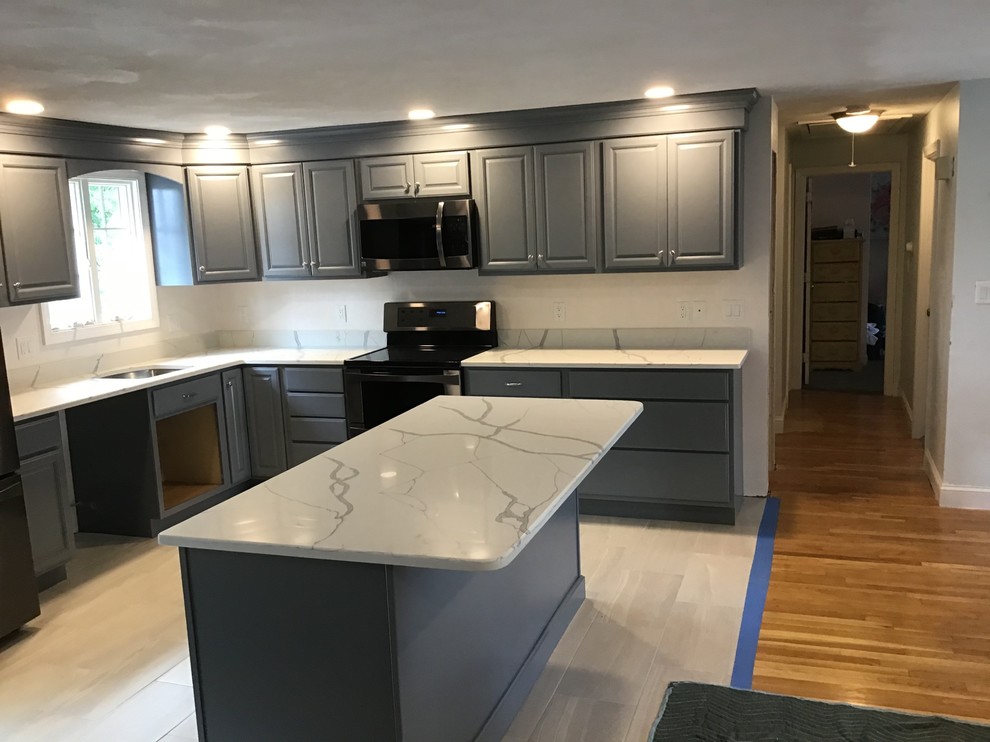 Mid-sized traditional l-shaped eat-in kitchen in Boston with an undermount sink, raised-panel cabinets, grey cabinets, onyx benchtops, black appliances, ceramic floors, with island and white floor.