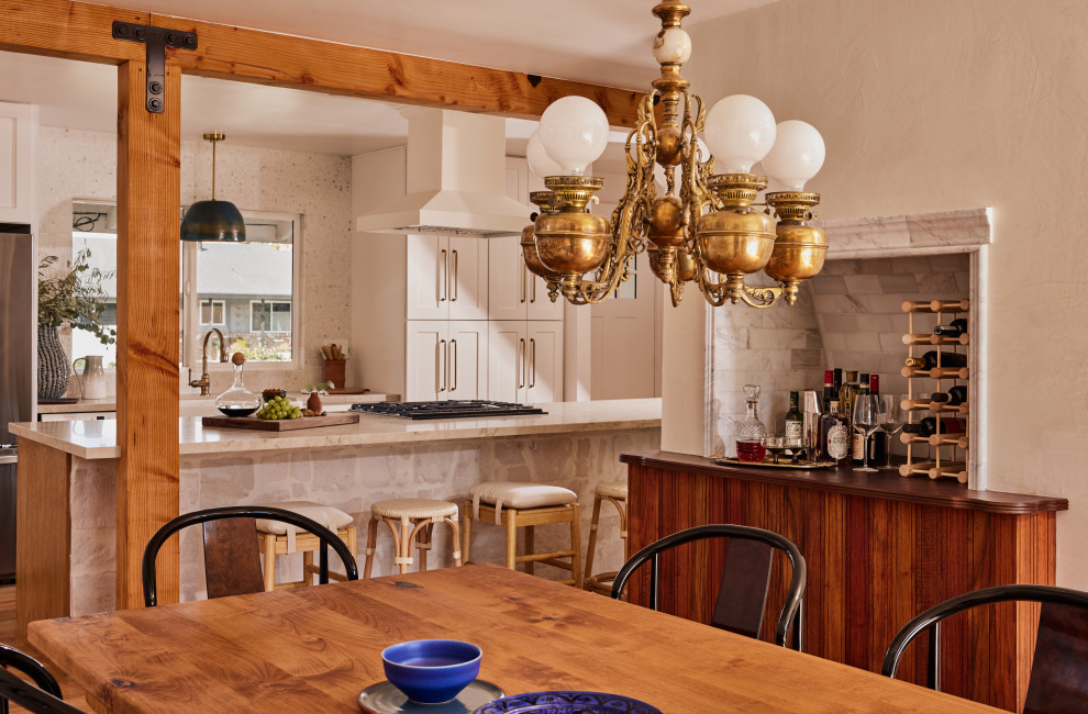На фото: маленькая кухня-столовая в средиземноморском стиле с белыми стенами, полом из ламината и коричневым полом для на участке и в саду с