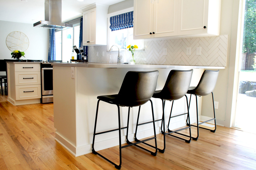 Inspiration for a mid-sized transitional u-shaped medium tone wood floor eat-in kitchen remodel in Seattle with an undermount sink, shaker cabinets, white cabinets, quartz countertops, white backsplash, ceramic backsplash, stainless steel appliances, a peninsula and gray countertops