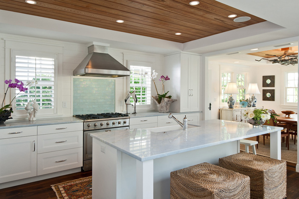 Design ideas for a beach style eat-in kitchen in Miami with a farmhouse sink, recessed-panel cabinets, white cabinets, subway tile splashback and stainless steel appliances.