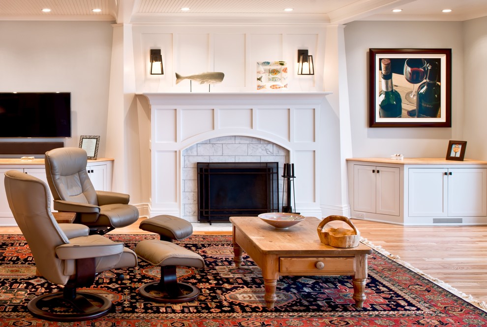 Design ideas for a mid-sized transitional formal enclosed living room in Chicago with white walls, light hardwood floors, a standard fireplace, a stone fireplace surround, a wall-mounted tv and brown floor.