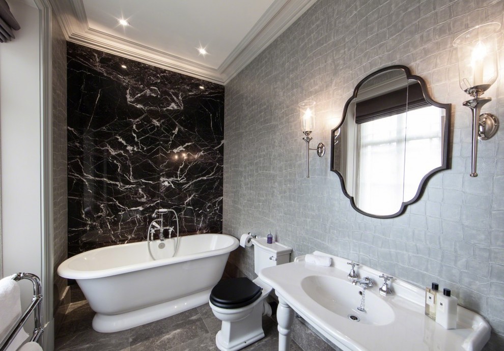 Contemporary bathroom in Cheshire with a console sink, a freestanding tub, a two-piece toilet, black tile, grey walls and marble floors.