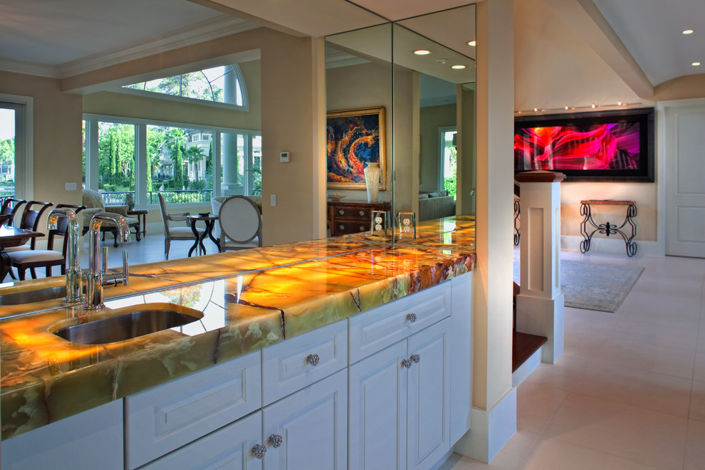 Mid-sized traditional single-wall wet bar in Charleston with an undermount sink, raised-panel cabinets, white cabinets, onyx benchtops and ceramic floors.
