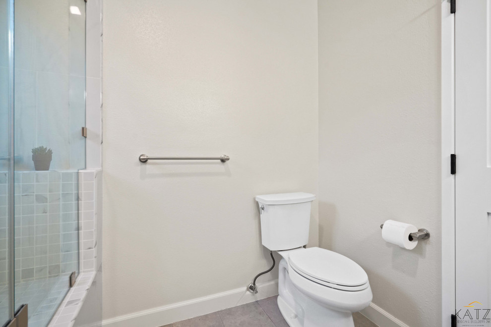 Bathroom - mid-sized white tile and marble tile medium tone wood floor, orange floor and single-sink bathroom idea in Orange County with blue cabinets, a one-piece toilet, beige walls, a console sink, marble countertops, white countertops and a built-in vanity