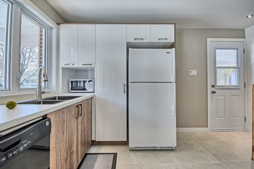 Small contemporary l-shaped eat-in kitchen in Montreal with an undermount sink, flat-panel cabinets, light wood cabinets, laminate benchtops, white splashback, subway tile splashback, white appliances, ceramic floors and a peninsula.