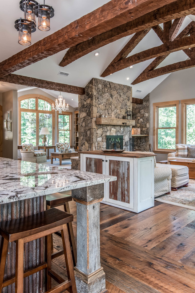 Mid-sized mountain style l-shaped medium tone wood floor and brown floor enclosed kitchen photo with a farmhouse sink, recessed-panel cabinets, white cabinets, granite countertops, white backsplash, subway tile backsplash, paneled appliances, an island and multicolored countertops