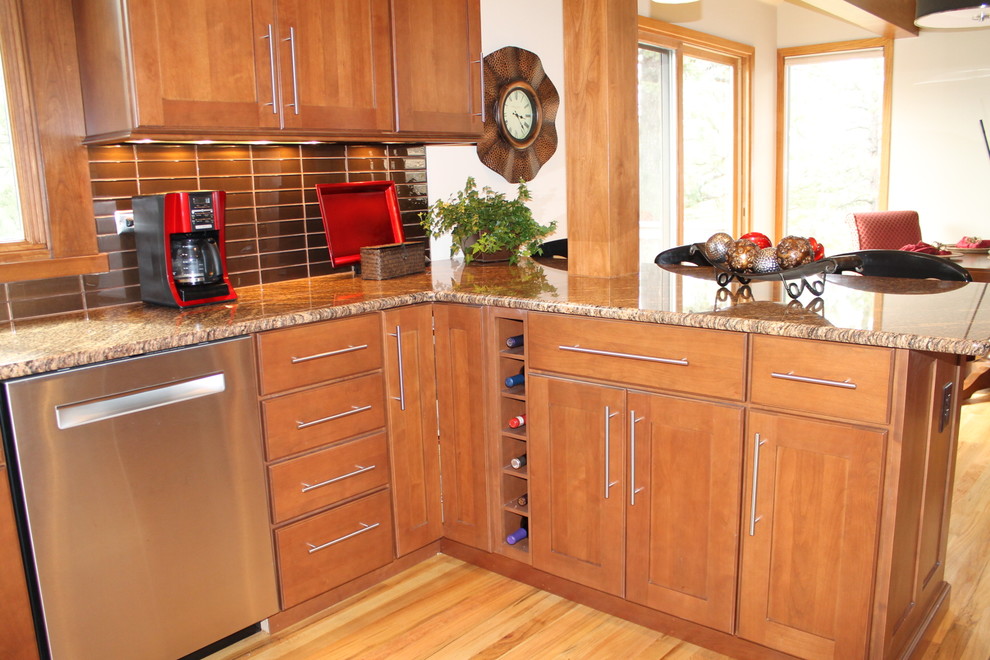 Large transitional u-shaped light wood floor eat-in kitchen photo in Denver with an undermount sink, flat-panel cabinets, dark wood cabinets, granite countertops, brown backsplash, glass tile backsplash, stainless steel appliances and a peninsula