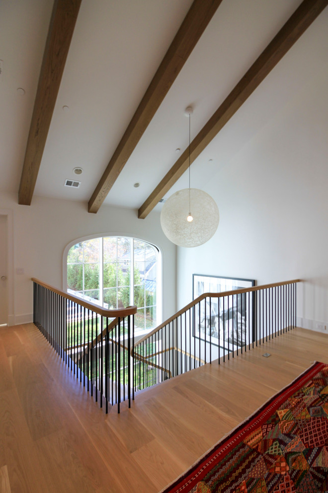 Immagine di un'ampia scala sospesa minimalista con pedata in legno, parapetto in materiali misti e pareti in perlinato